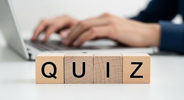 Person taking an online quiz on a laptop computer at a desk focusing on wooden blocks spelling QUIZ creating a concept of elearning testing knowledge and interactive education in a modern setting photo