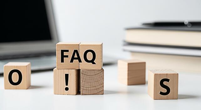 Wooden blocks spelling FAQ on a white desk with a laptop and books representing frequently asked questions and information resources in a clean modern office environment conveying clarity and support photo