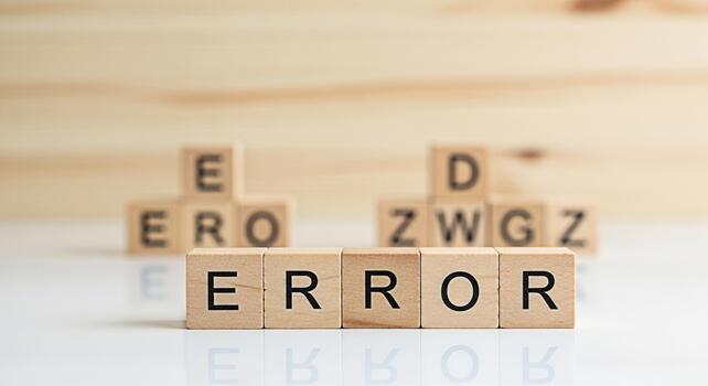 Wooden blocks spelling ERROR on a white surface representing a system failure in a clean minimalist setting conveying a sense of frustration and the need for problemsolving and technical support photo