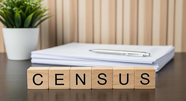 Wooden blocks spelling Census on a desk next to a stack of papers and a pen symbolizing the importance of population counting and demographic data collection for government and community planning photo
