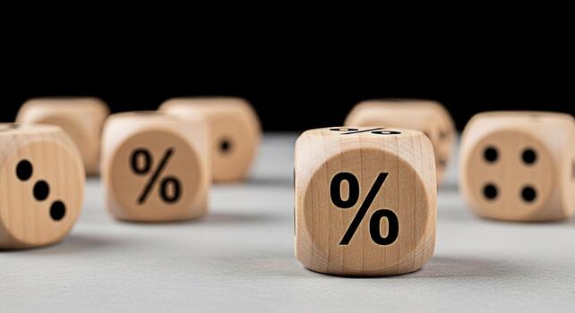 Wooden dice displaying percentage signs and numbers on a neutral surface representing financial rates and calculations conveying a sense of risk investment and statistical analysis in business photo