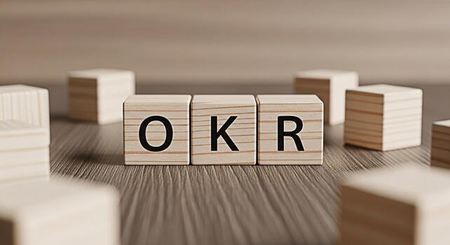 Wooden blocks spelling out OKR on a wooden surface representing objectives and key results in a business setting conveying a sense of focus and strategic planning for success photo