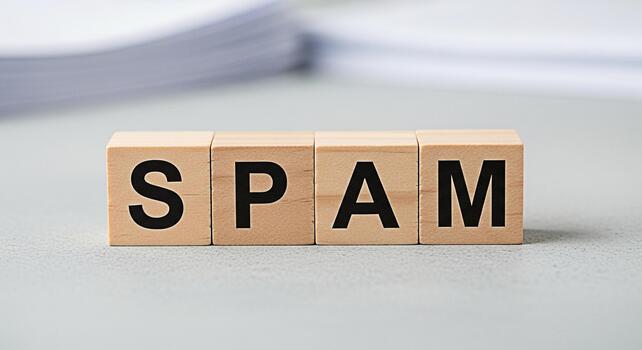 Wooden blocks spelling SPAM on a gray surface representing unwanted emails and messages in a digital environment creating a negative and frustrating mood for users and businesses alike photo