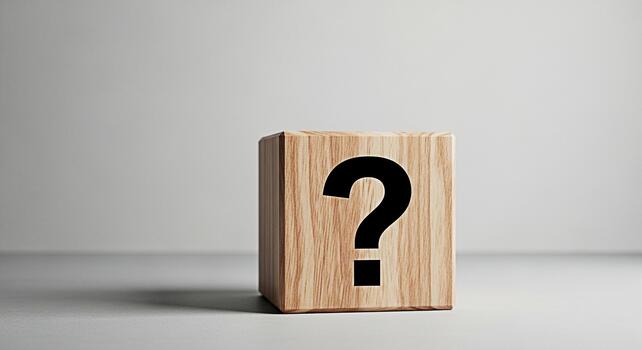 Wooden cube displaying a question mark in a minimalist studio setting representing uncertainty and the need for answers sparking curiosity and inviting exploration of solutions and knowledge photo