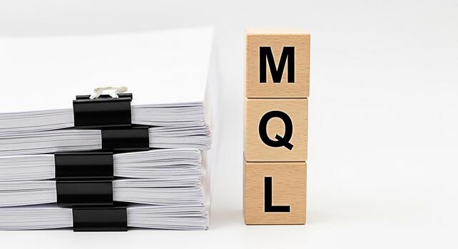 Stack of documents with binder clips and wooden blocks spelling MQL on a white surface representing marketing qualified leads lead generation and business development in a clean and organized environm photo