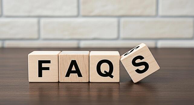 Wooden blocks spelling FAQs on a wooden table in front of a brick wall representing frequently asked questions and information resources with a clean and professional presentation photo