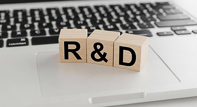Wooden blocks spelling RD resting on a laptop keyboard symbolizing research and development in a techdriven environment conveying innovation progress and the importance of technology in business strat photo