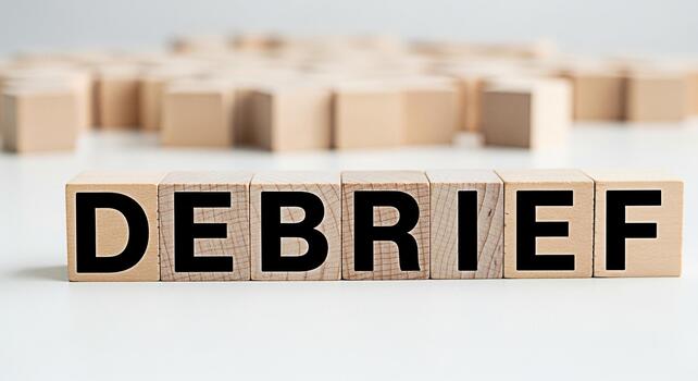 Wooden blocks spelling out DEBRIEF on a white surface representing a review process in a corporate setting highlighting the importance of analysis and learning from past experiences for future improve photo