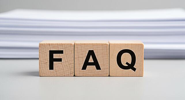 Wooden blocks displaying FAQ on a neutral surface with stacked papers in the background representing frequently asked questions and information resources in a clear and accessible manner photo