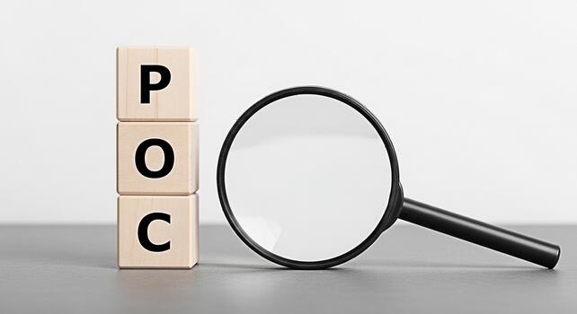 Wooden blocks displaying POC being examined with a magnifying glass on a neutral surface symbolizing proof of concept investigation and validation in a minimalist and focused setting photo