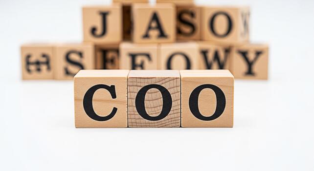 Wooden blocks spelling COO on a white surface symbolizing the Chief Operating Officer role with other blurred blocks in the background representing business hierarchy and corporate structure in a mini photo