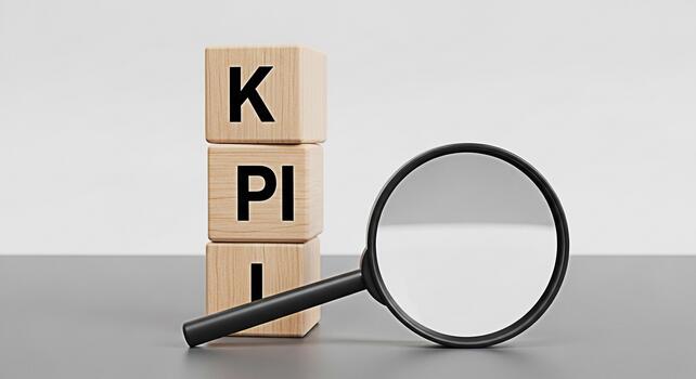 Wooden blocks displaying KPI are analyzed with a magnifying glass on a gray surface symbolizing performance measurement and strategic business planning in a minimalist modern setting photo