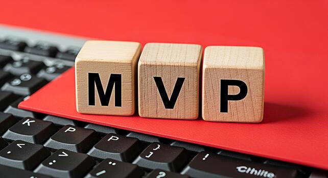 Wooden blocks displaying MVP acronym resting on a red surface and keyboard symbolizing a minimum viable product in a techdriven environment conveying innovation and strategic business development photo