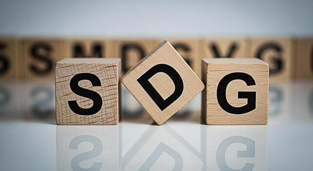 Wooden blocks spelling SDG reflecting on a white surface symbolizing Sustainable Development Goals in a conceptual and minimalist setting promoting global responsibility and environmental awareness photo