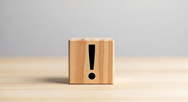 Wooden block displaying an exclamation point on a light wooden surface symbolizing urgency and attention to detail in a minimalist and clean studio environment conveying a message of importance photo