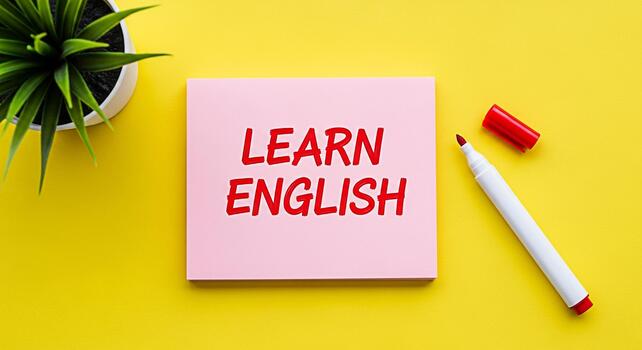 rosado bloc mostrando aprender Inglés en un vibrante amarillo superficie acompañado por un marcador y un en conserva planta simbolizando educación idioma adquisición y un positivo aprendizaje ambiente foto