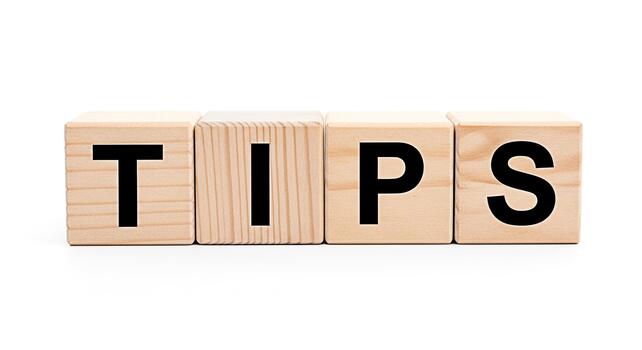 Wooden blocks spelling out TIPS on a white surface offering guidance and advice in a clean and minimalist setting conveying a sense of helpfulness and clarity for problemsolving photo