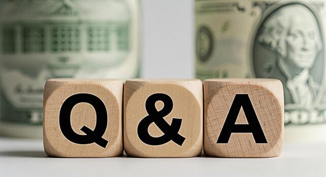 Wooden blocks displaying Q A sitting on a white surface with blurred dollar bills in the background representing financial questions and answers and creating a sense of clarity and financial literacy photo