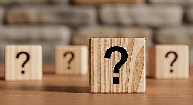 Wooden blocks displaying question marks on a wooden surface in a studio setting representing uncertainty inquiry and the search for answers in business education and personal life photo