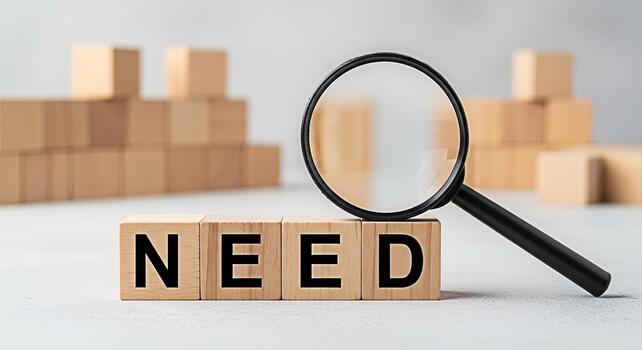 Magnifying glass focusing on the word NEED spelled out with wooden blocks on a white surface symbolizing the identification of requirements and problemsolving in a minimalist and clean setting photo