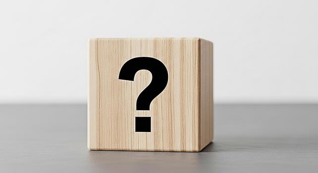 Wooden block displaying a question mark on a gray surface symbolizing uncertainty and curiosity in a minimalist studio setting evoking a sense of inquiry and problemsolving photo