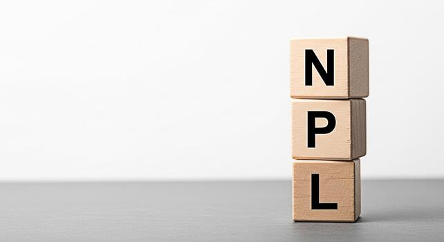 Wooden blocks displaying NPL on a gray surface against a white background representing NonPerforming Loans in a financial setting symbolizing risk debt and economic challenges in the banking sector photo