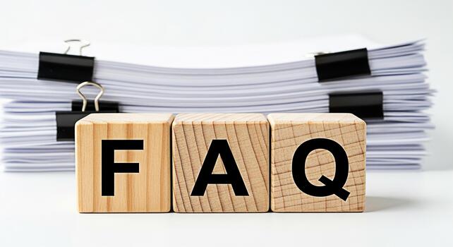 Wooden blocks displaying FAQ in front of a stack of papers on a white desk representing frequently asked questions and information resources for customer support and business solutions photo