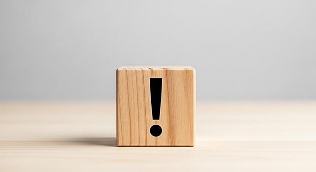 Wooden block displaying an exclamation mark on a wooden surface against a neutral background symbolizing urgency attention and the importance of critical information and problemsolving photo