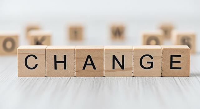 Wooden blocks spelling CHANGE on a gray surface symbolizing transformation and progress in a bright minimalist setting representing opportunity and the potential for positive development photo