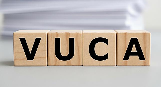 Wooden blocks spelling VUCA on a gray surface representing volatility uncertainty complexity and ambiguity in a business environment conveying a sense of challenge and strategic planning photo