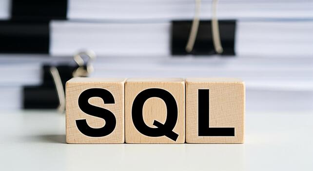 Wooden blocks displaying SQL on a white desk with blurred documents in the background representing database management data analysis and the importance of structured query language in modern technolog photo