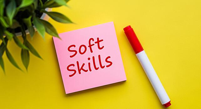 Pink sticky note displaying Soft Skills on a vibrant yellow background with a red marker and green plant representing essential skills for career development and personal growth in a positive setting photo