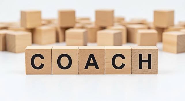 Wooden blocks spelling COACH on a white surface symbolizing guidance and support in a learning environment creating a motivational and inspiring mood for personal and professional development photo