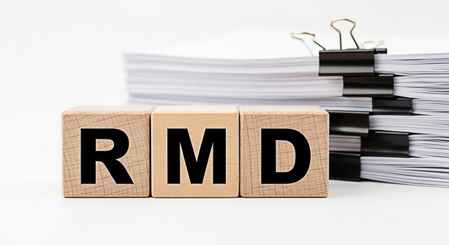 Wooden blocks displaying the letters RMD in a bright studio setting representing required minimum distributions and retirement planning with a focus on financial responsibility and future security photo