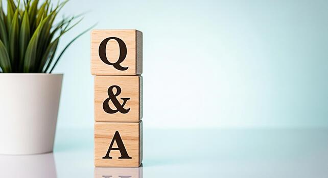 Wooden blocks displaying QA on a reflective surface next to a potted plant symbolizing knowledge and information in a bright clean studio environment creating a sense of clarity and understanding photo