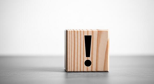 Wooden block displaying an exclamation mark on a gray surface against a white background symbolizing urgency attention and the importance of problemsolving in a minimalist and clean setting photo