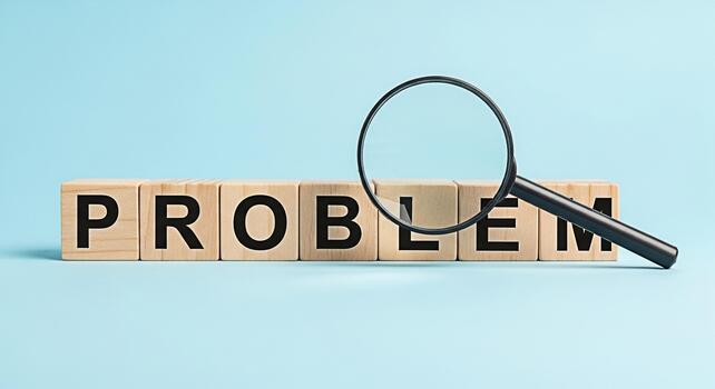 Magnifying glass examining the word PROBLEM spelled out with wooden blocks on a light blue background representing a challenge issue or obstacle requiring analysis and solution with a focused perspect photo