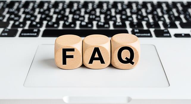 Wooden blocks displaying FAQ on a laptop keyboard representing frequently asked questions and information retrieval in a digital environment conveying clarity and accessibility for online support photo