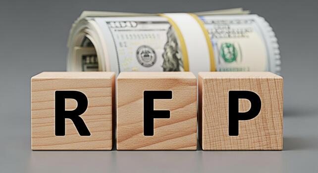 Wooden blocks spelling RFP in a neutral setting representing a request for proposal and financial opportunity suggesting investment and business growth with a roll of US dollar bills in the background photo