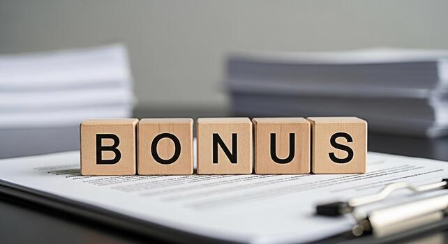 Wooden blocks spelling BONUS on a contract in a bright office setting representing financial incentives and employee motivation creating a positive and rewarding work environment photo