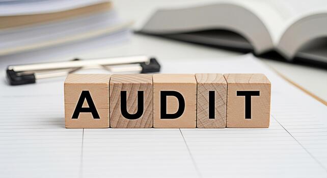 Wooden blocks spelling AUDIT on a lined paper surface symbolizing financial review and assessment in a business environment conveying a sense of accountability and transparency photo
