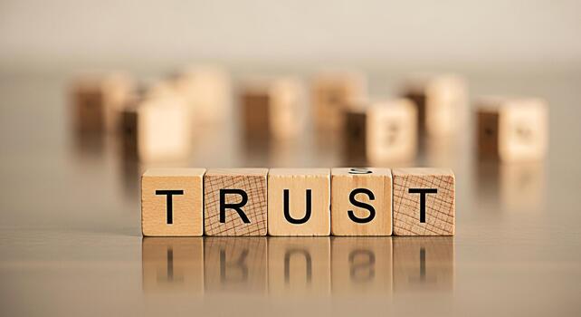 Wooden blocks spelling TRUST on a reflective surface symbolizing reliability and confidence in a business setting promoting a sense of security and longterm partnerships photo