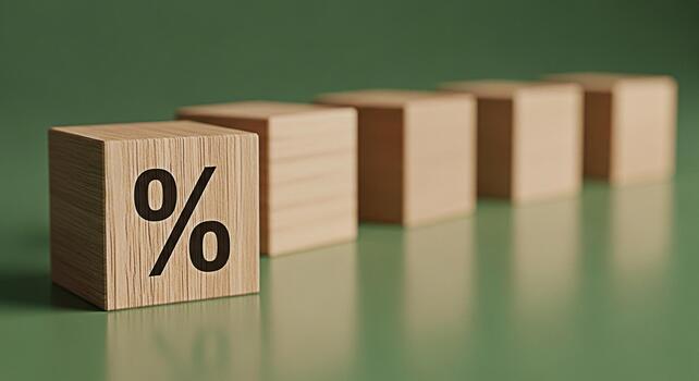 Wooden blocks displaying a percentage symbol on a green surface representing financial interest rates and discounts creating a sense of stability and growth in a minimalist setting photo