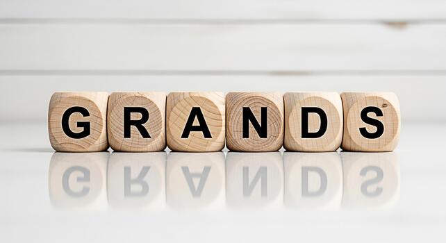 Wooden blocks spelling GRANDS on a white surface reflecting the word symbolizing success and achievement in a clean minimalist setting conveying a message of ambition and financial goals photo