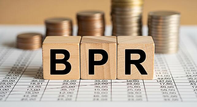 Wooden blocks spelling BPR on financial data sheet with stacked coins representing Business Process Reengineering for improved efficiency and profitability in a corporate environment photo