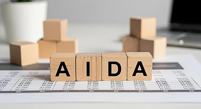 Wooden blocks spelling AIDA resting on a financial report in a bright office setting symbolizing marketing strategies and business success with attention interest desire and action photo