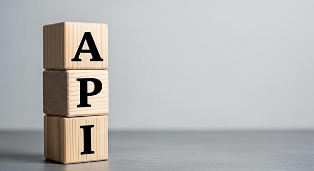 Wooden blocks displaying API in a studio setting representing application programming interface and software development conveying a clean and modern concept with a focus on technology and innovation photo