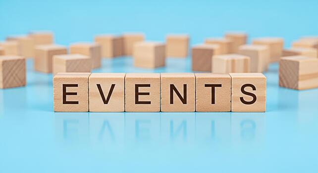 Wooden blocks spelling EVENTS on a blue surface representing event planning and management creating a sense of organization anticipation and excitement for upcoming gatherings and occasions photo