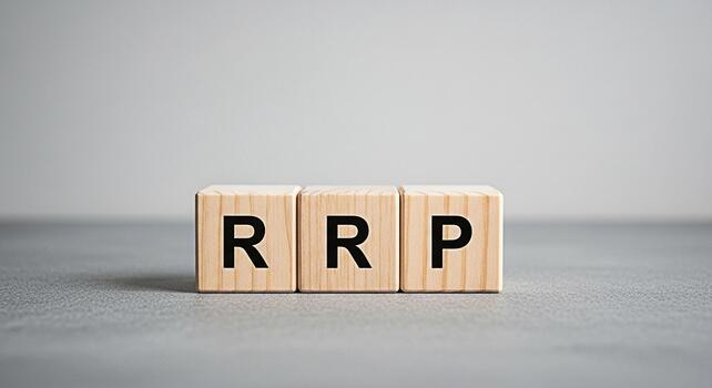 Wooden blocks displaying the letters RRP on a gray surface representing the concept of Recommended Retail Price in a simple and minimalist setting conveying clarity and focus on pricing strategy photo