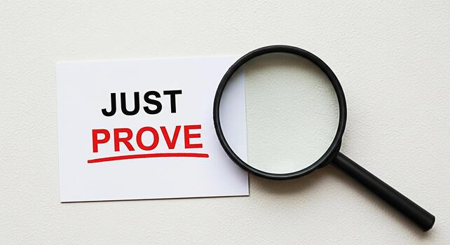 Magnifying glass examining a card with the words Just Prove on a textured white surface symbolizing investigation verification and the need for evidence in a clear and concise manner photo
